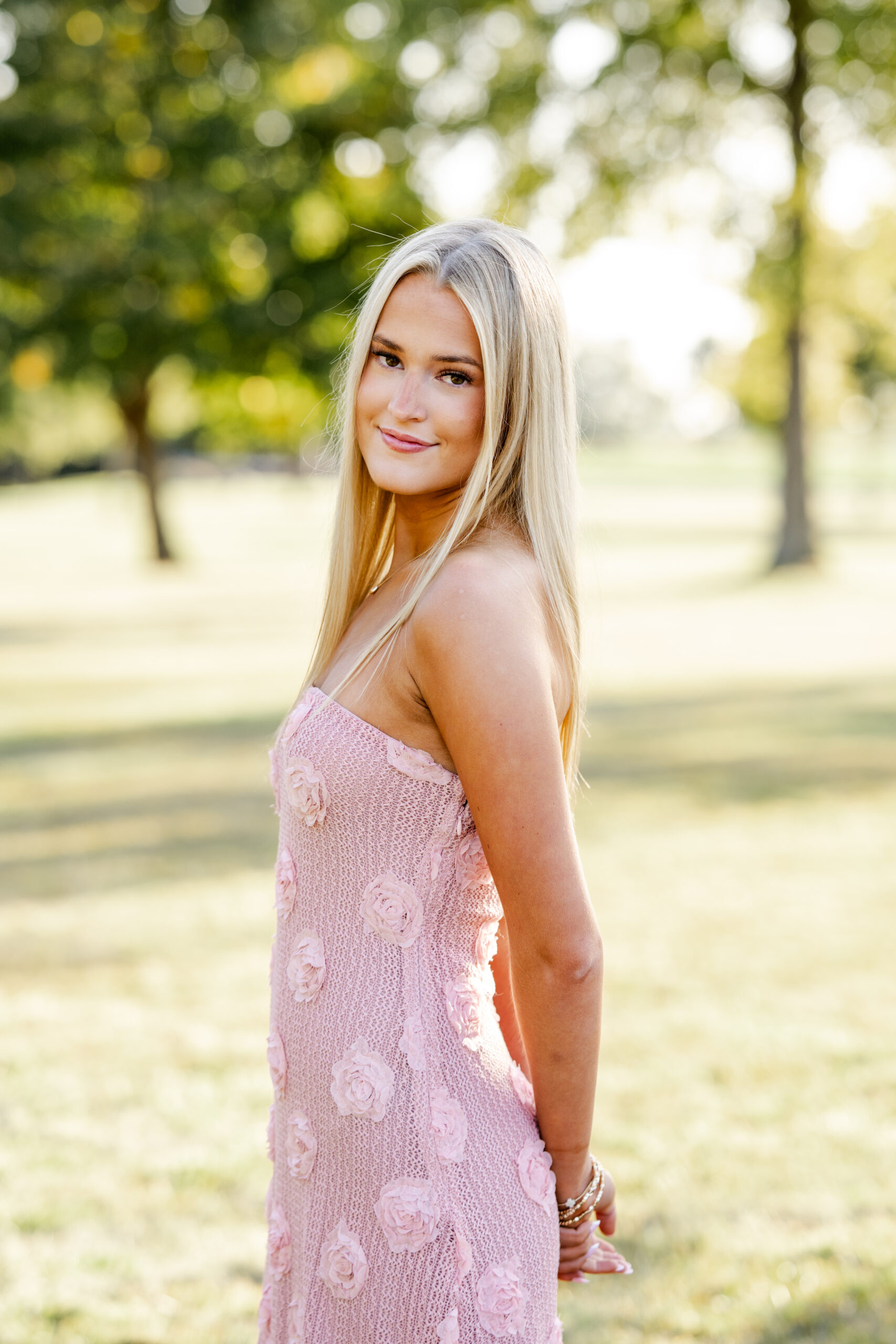Senior girl poses in warm evening sunlight for golden hour in Sheridan, Indiana.