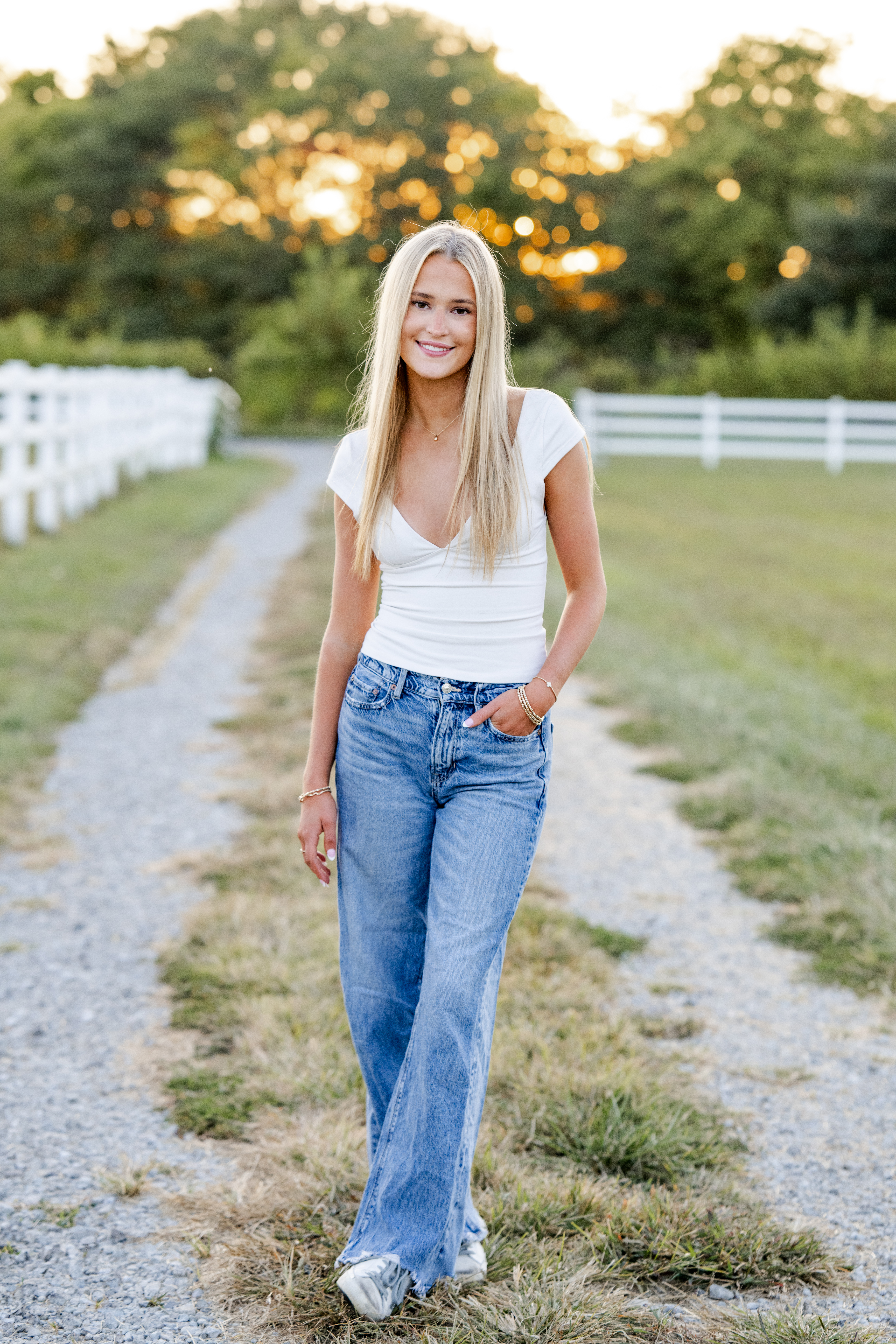 Westfield High School senior in jeans and a white tee poses casually at home farm in Sheridan, Indiana.