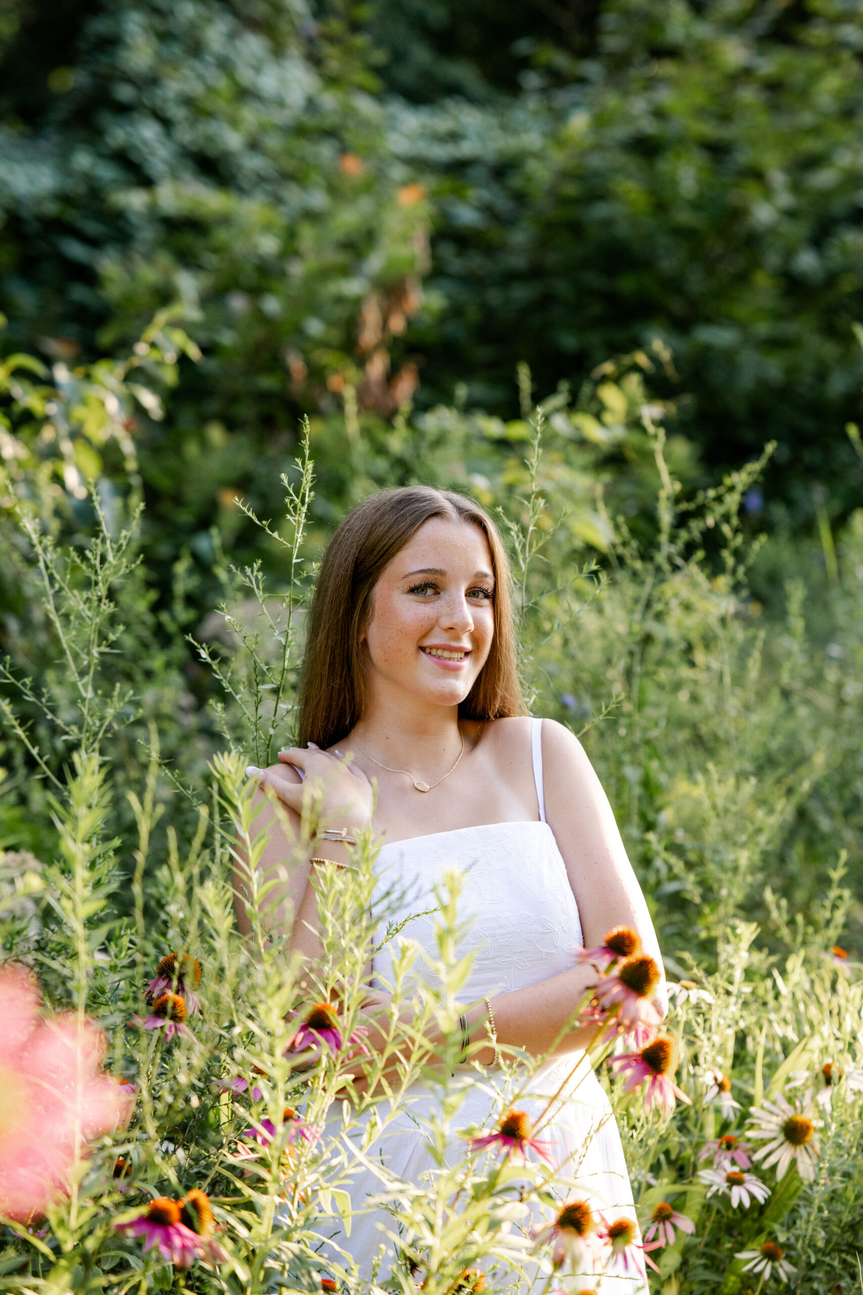 Teenage senior poses at Newfields during golden hour for her senior portraits in Indianapolis, photographed by Kate Kosnoff